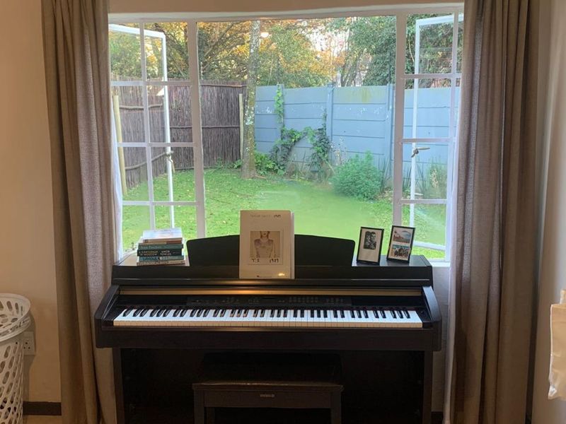 A bedroom featuring a large casement window with views of the rear garden, providing natural light and a pleasant outlook.