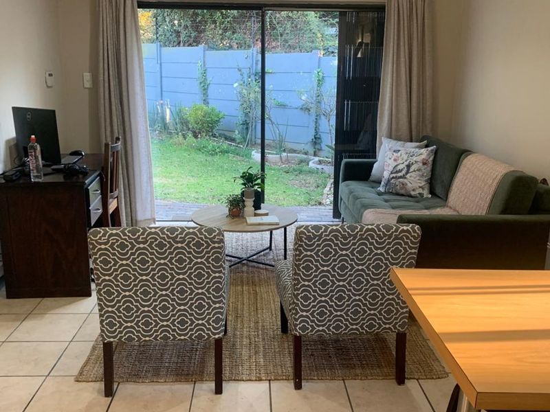 Open plan living area featuring tiled flooring and large sliding glass doors providing direct access to the rear garden.