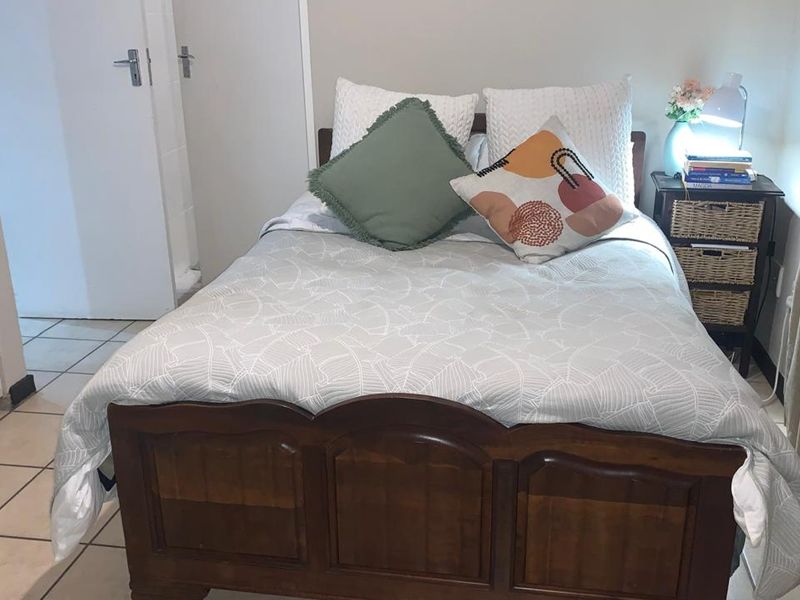 A bedroom featuring tiled flooring and a neutral wall finish, providing a functional space for rest.
