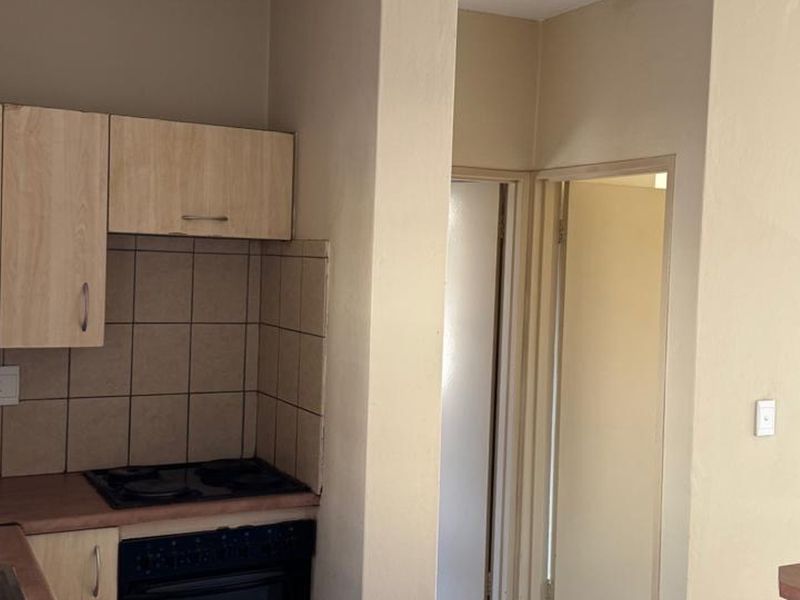A functional kitchen area featuring built-in cabinetry, a tiled backsplash, and integrated cooking appliances, providing a practical layout for daily use.