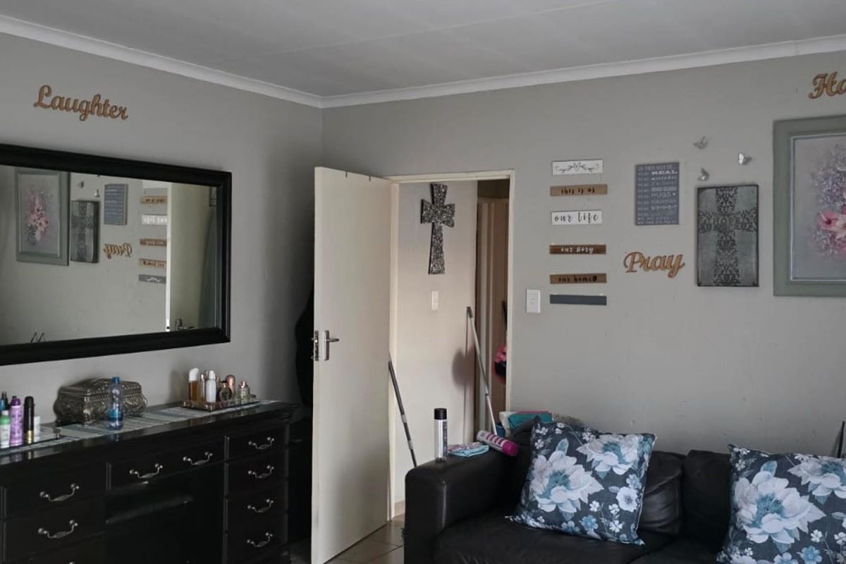 A living room area featuring neutral wall paint, coving, and an internal door leading to an adjacent space.