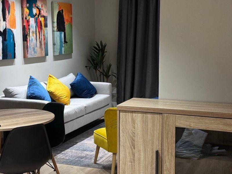 A well-maintained living area featuring modern laminate flooring and recessed lighting, creating a comfortable and inviting space for relaxation.