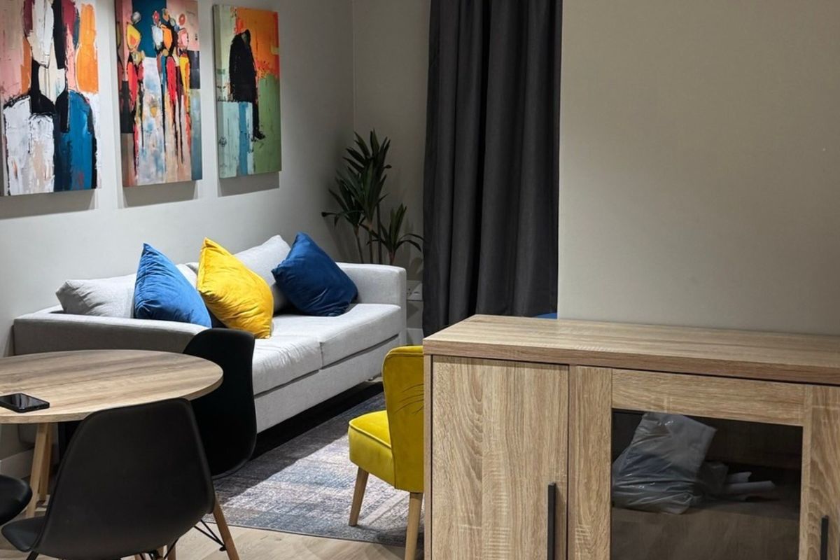 A well-maintained living area featuring modern laminate flooring and recessed lighting, creating a comfortable and inviting space for relaxation.