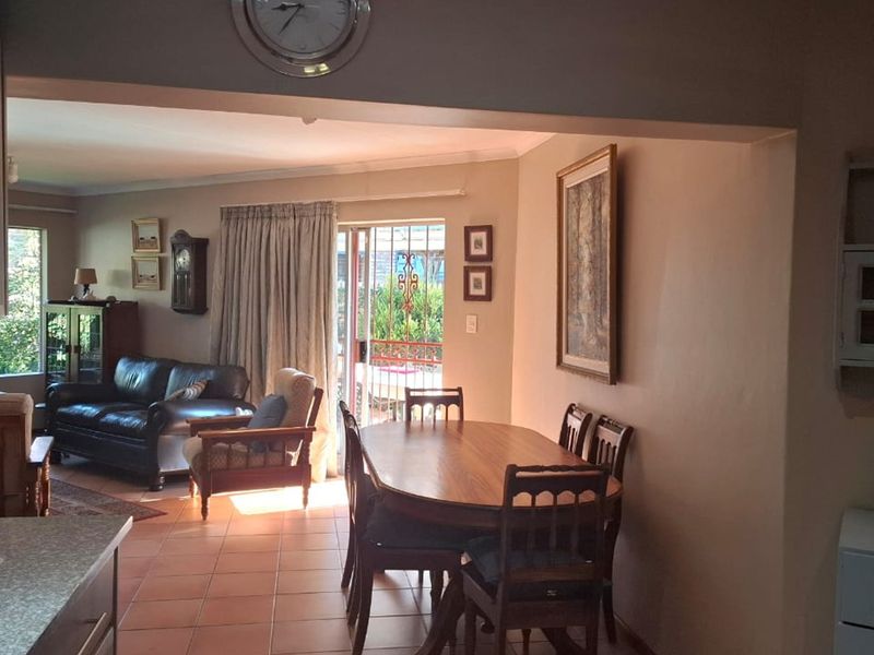Open plan living and dining area featuring tiled flooring and direct access to the outdoor space through a sliding glass door.