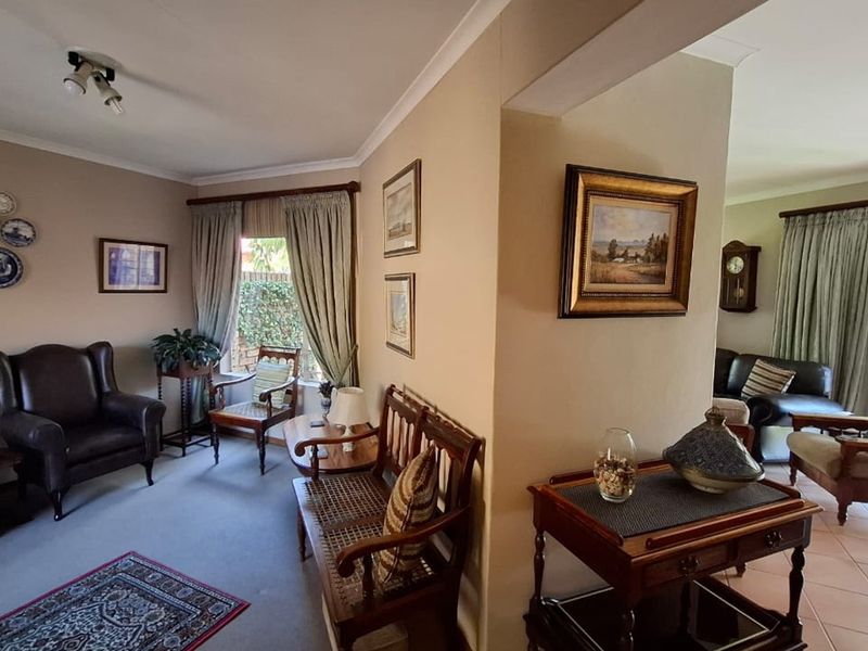Open plan living area featuring a combination of carpeted and tiled flooring, with access to an outdoor patio through sliding glass doors.