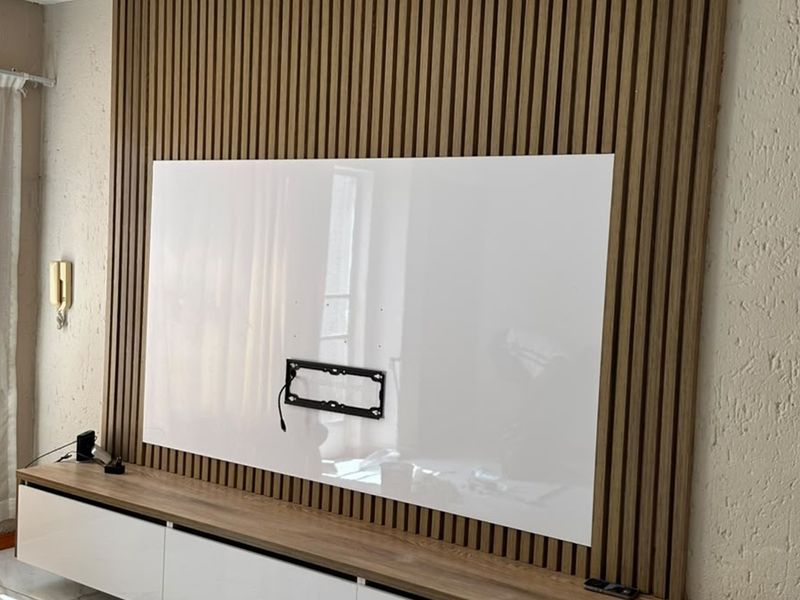 A modern living room feature wall showcasing vertical slatted wood paneling, a built-in media console, and a dedicated wall-mounted television bracket.