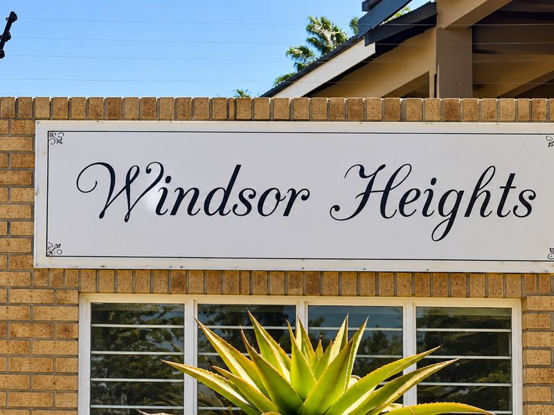 Exterior view of the Windsor Heights complex entrance featuring a brick facade and security features.