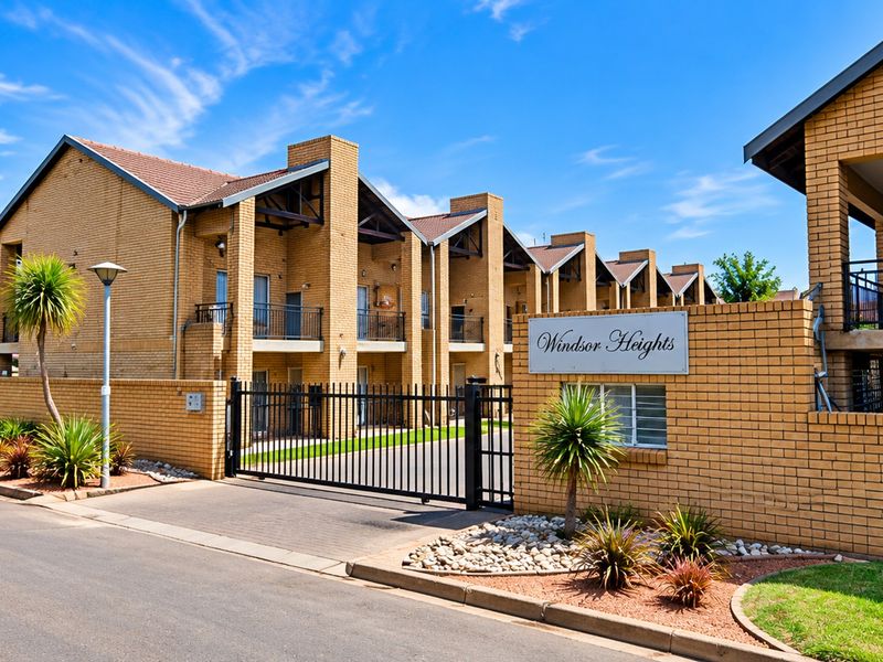 Street view of the Windsor Heights apartment complex, featuring face brick architecture, secure gated access, and private balconies.