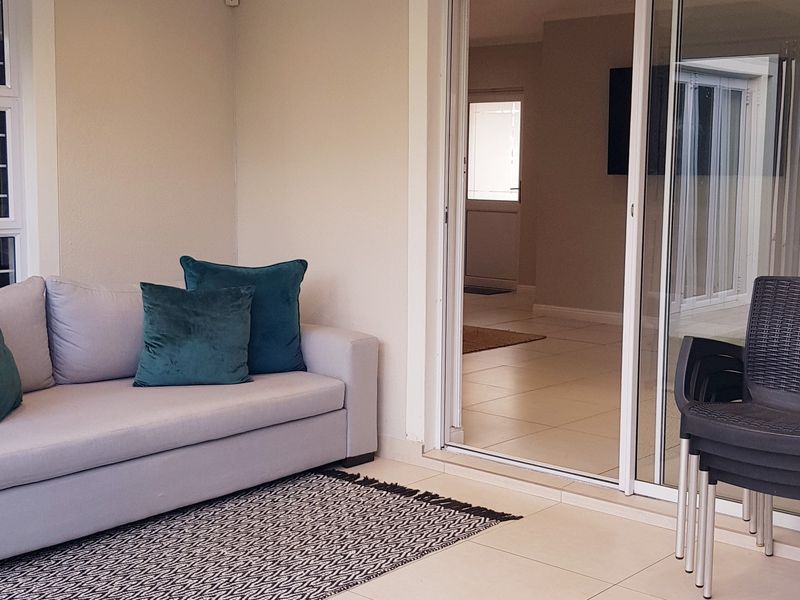 A covered patio area featuring tiled flooring and sliding glass doors providing seamless access to the interior living space.