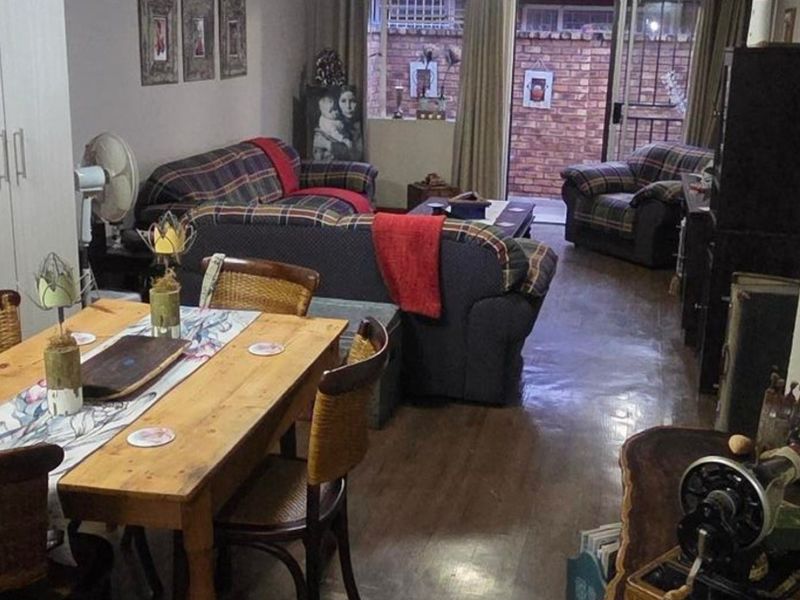 Open plan living and dining area featuring laminate flooring and direct access to an outdoor patio through a sliding glass door.
