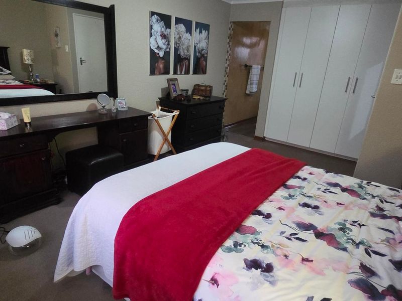 A carpeted bedroom featuring built-in cupboards and neutral wall finishes, offering a functional and comfortable living space.