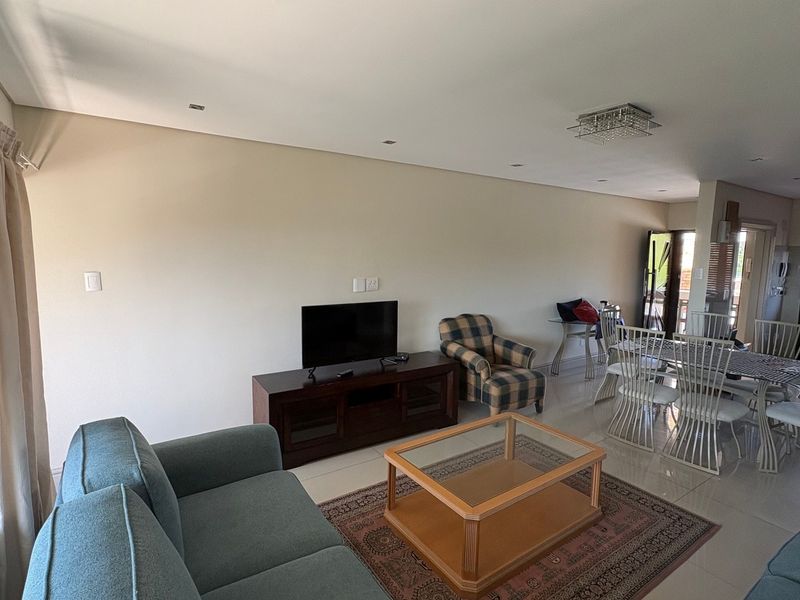 Spacious open-plan living and dining area featuring tiled floors, recessed lighting, and seamless flow to the kitchen and outdoor access.