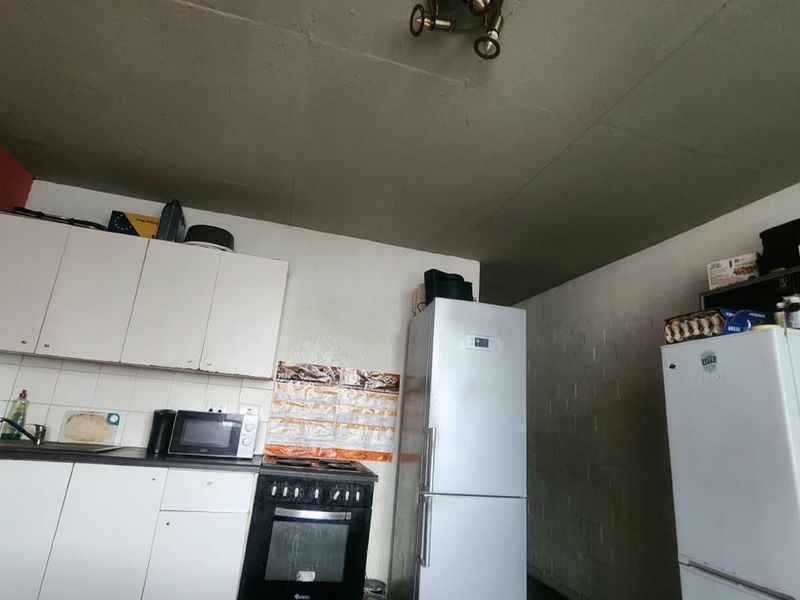 A functional kitchen area featuring built-in cabinetry, a stove, and an oven, with potential for cosmetic updates to improve the overall finish.
