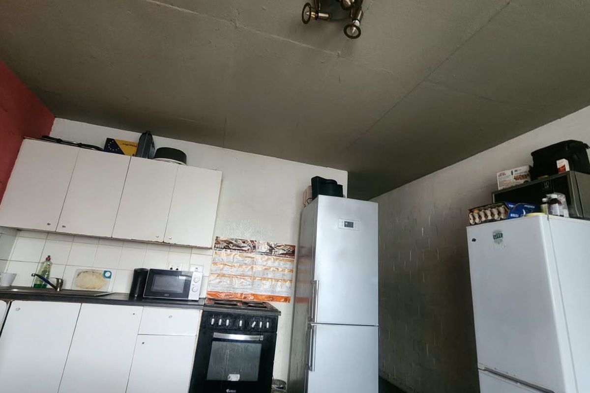A functional kitchen area featuring built-in cabinetry, a stove, and an oven, with potential for cosmetic updates to improve the overall finish.