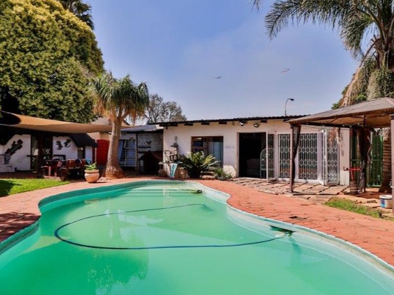 Outdoor pool area featuring a swimming pool, paved surround, gazebo, and shade sail, providing a functional space for outdoor relaxation and entertainment.