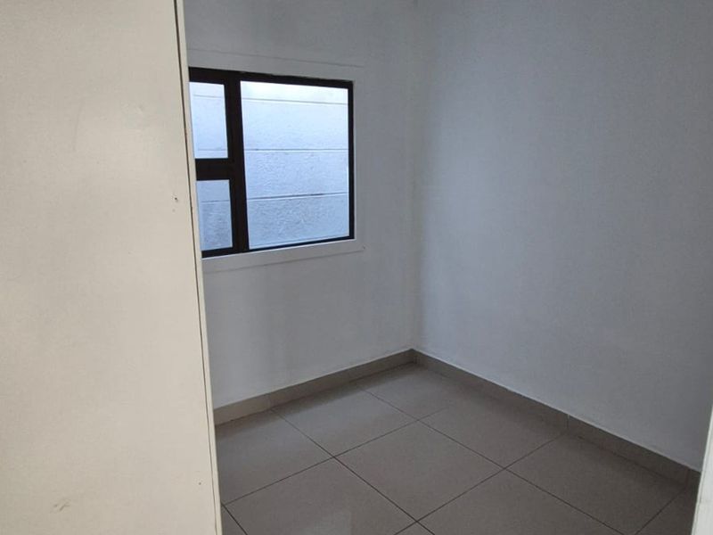 A clean, empty bedroom featuring neutral tiled flooring and a modern aluminium-framed window, providing a blank canvas for personalization.