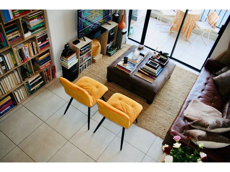 A well-lit living room featuring tiled flooring, built-in shelving, and large sliding glass doors providing access to an outdoor balcony area.