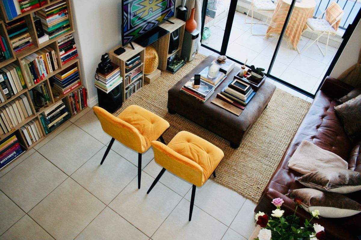 A well-lit living room featuring tiled flooring, built-in shelving, and large sliding glass doors providing access to an outdoor balcony area.