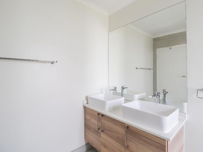 Modern bathroom featuring a double vanity with vessel sinks, a large wall-mounted mirror, and chrome fixtures.
