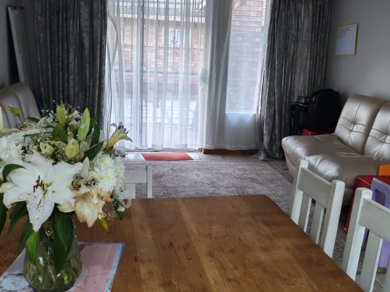 A living area featuring tiled flooring and a sliding glass door providing access to the exterior.