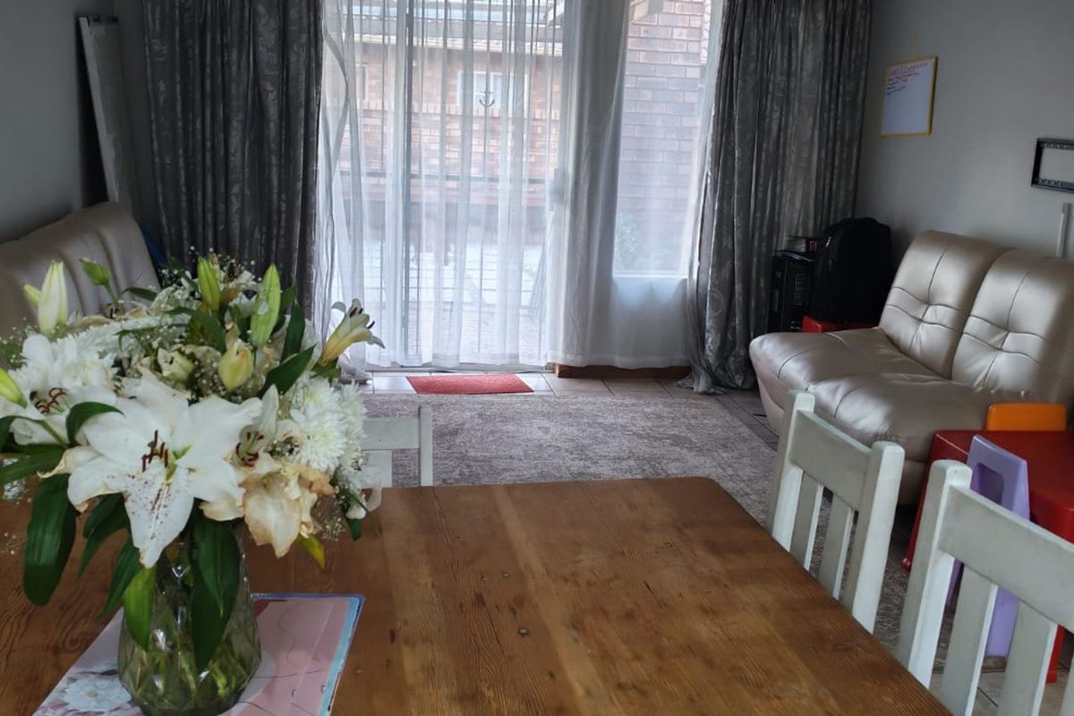 A living area featuring tiled flooring and a sliding glass door providing access to the exterior.