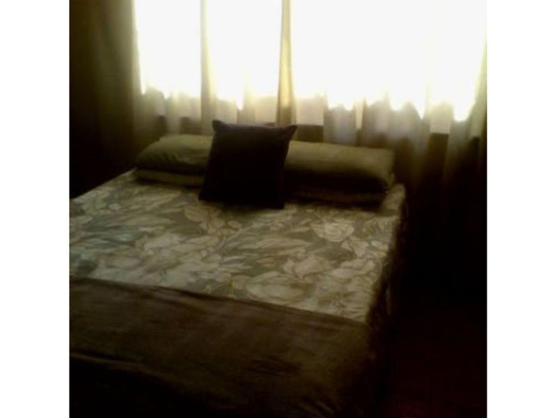 A bedroom interior featuring a window with curtains.
