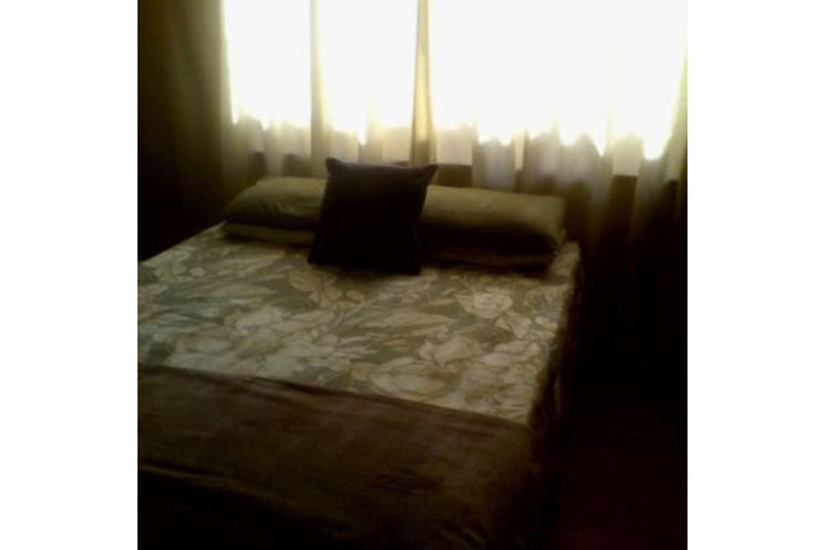 A bedroom interior featuring a window with curtains.