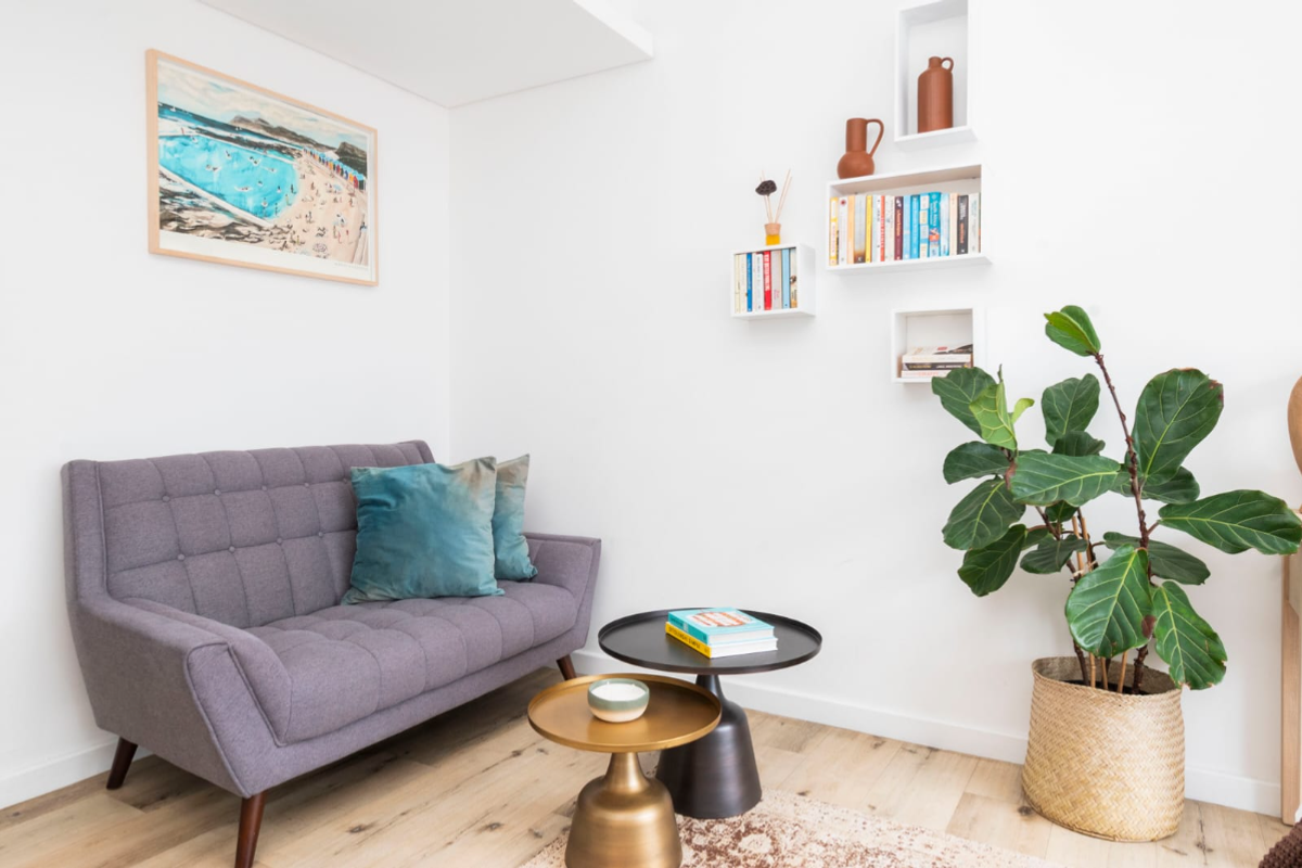 A bright and modern living area featuring light timber flooring and minimalist built-in wall shelving, creating a clean and inviting space.