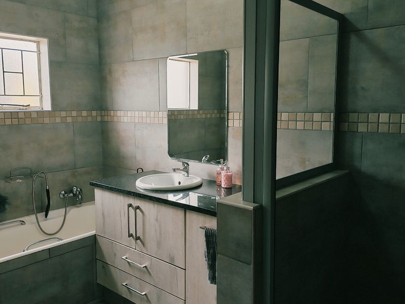 A well-appointed bathroom featuring a built-in vanity with granite countertop, a drop-in basin, a bathtub, and a separate shower enclosure with tiled finishes.