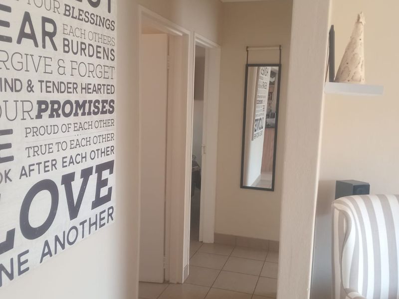 A functional hallway featuring tiled flooring and an archway connecting to adjacent rooms within the townhouse.
