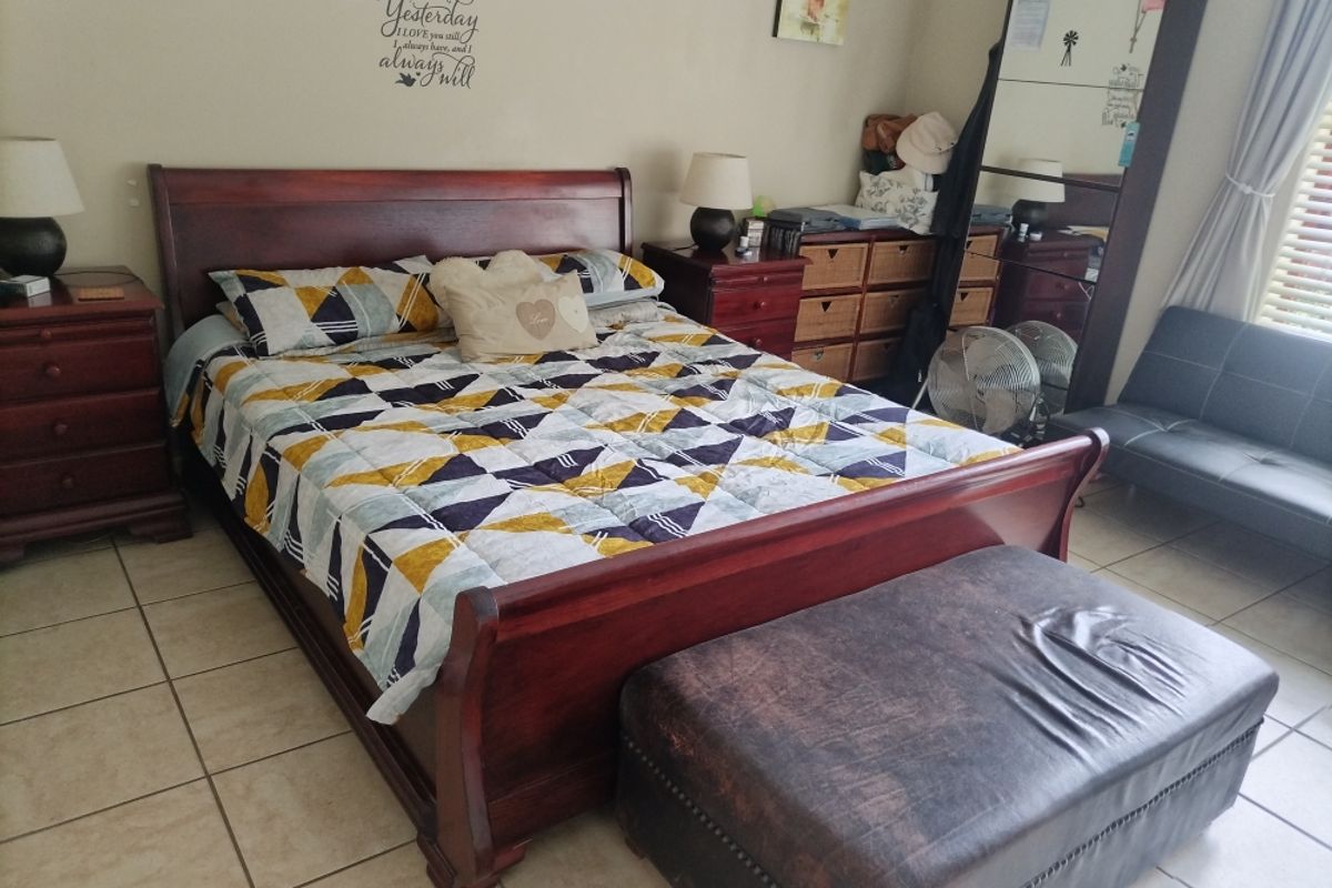 A bedroom featuring tiled flooring and neutral wall finishes, providing a functional space for rest.