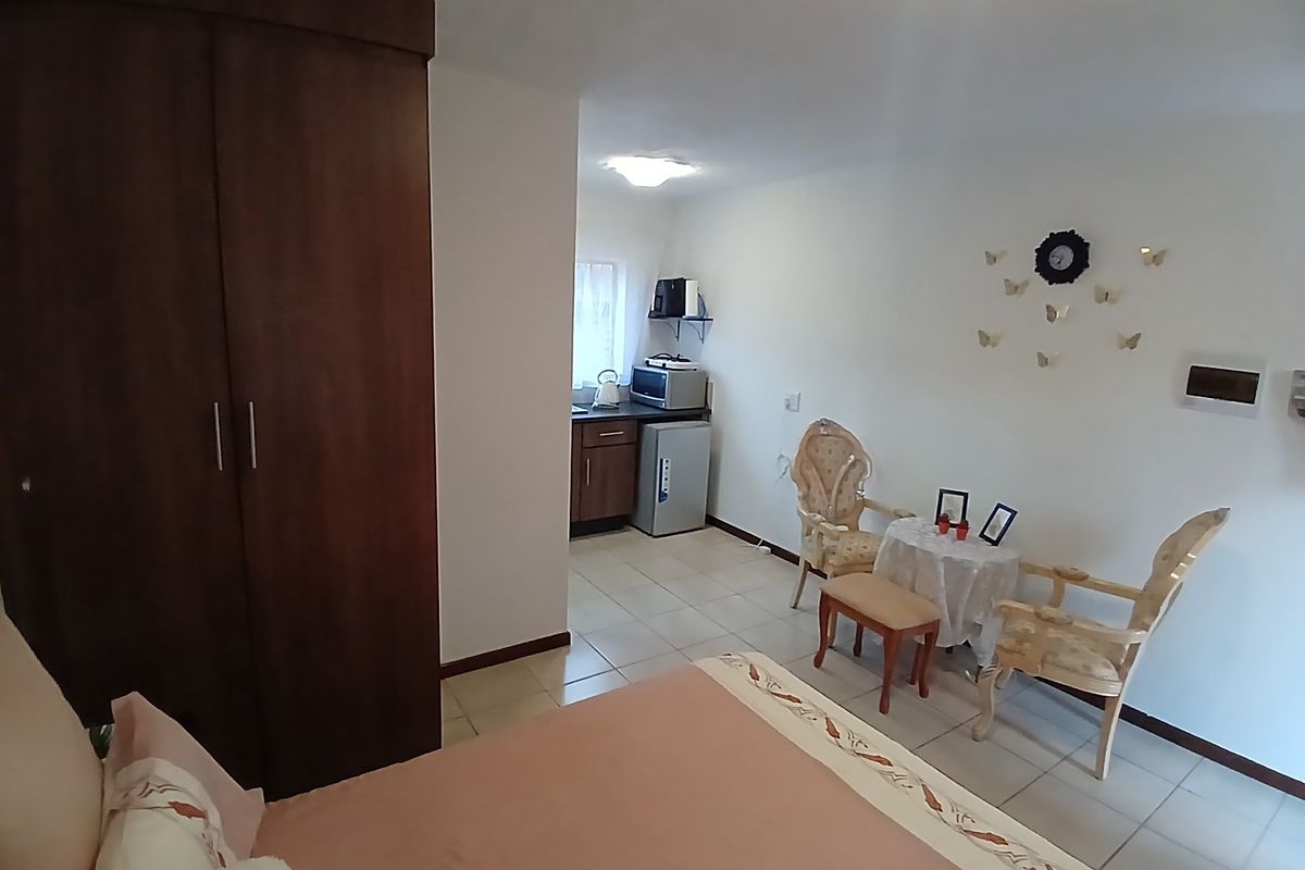Open-plan studio apartment featuring a built-in wardrobe, tiled flooring, and a compact kitchenette area.