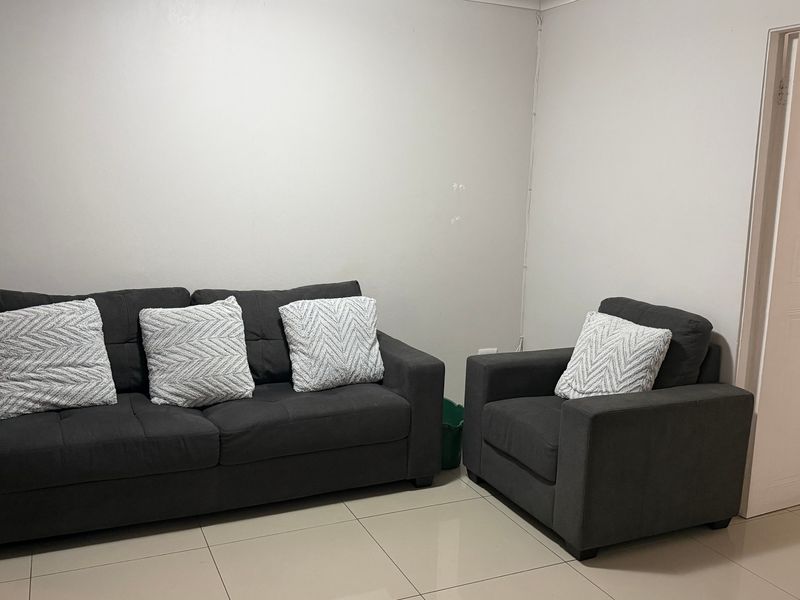 A simple living room area featuring neutral tiled flooring and plain walls, providing a functional and blank canvas for interior design.