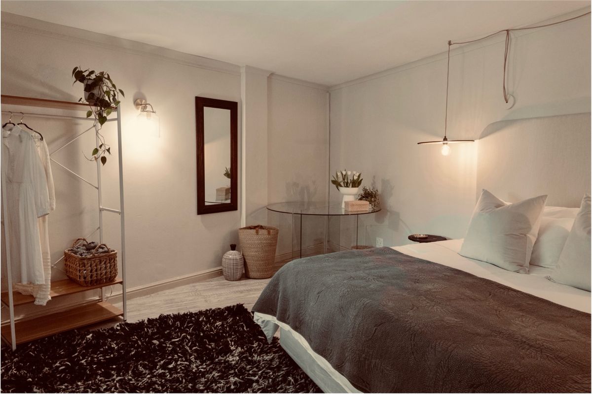 A cozy bedroom featuring warm ambient lighting, a neutral color palette, and a clean, well-maintained interior finish.