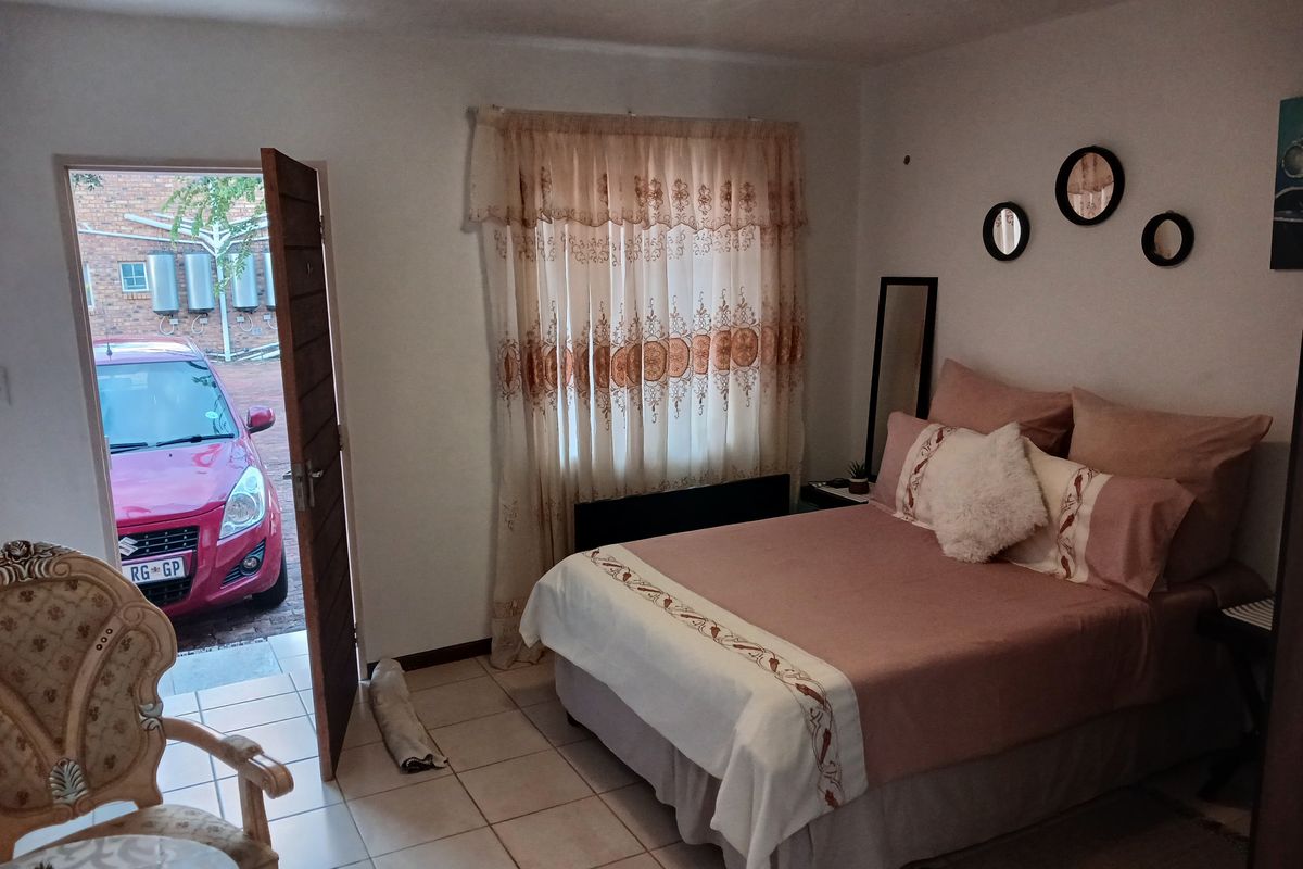 A bedroom featuring tiled flooring and direct access to the exterior parking area.