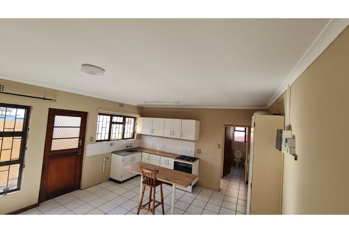 Functional kitchen featuring built-in cabinetry, tiled flooring, a gas hob, and a tiled backsplash, with direct access to an adjacent bathroom.