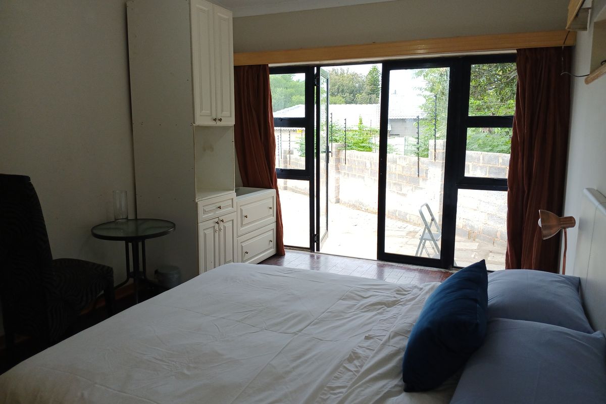 A bedroom featuring built-in cabinetry and a sliding glass door providing direct access to an outdoor area.
