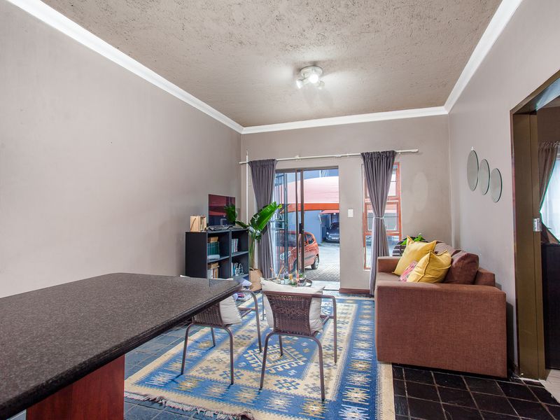 Open plan living area featuring a granite breakfast bar, tiled flooring, and sliding glass doors leading to the exterior.