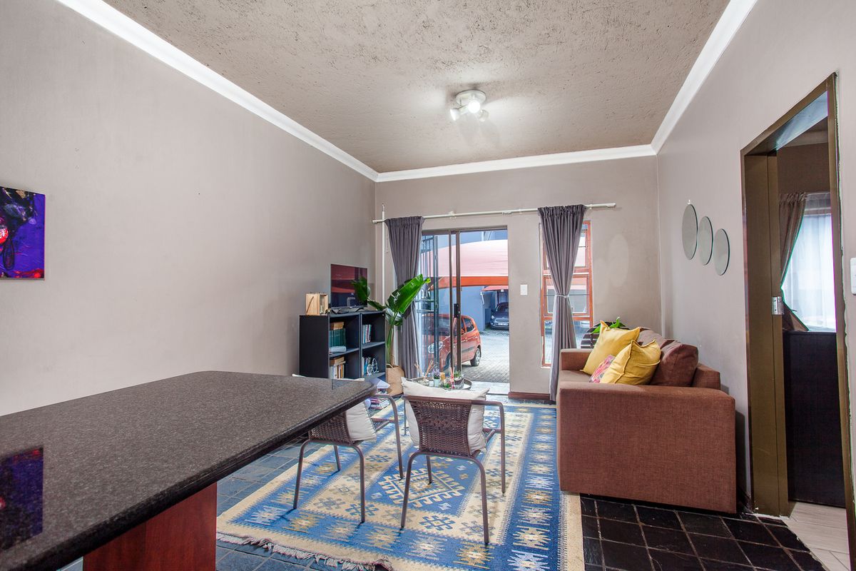 Open plan living area featuring a granite breakfast bar, tiled flooring, and sliding glass doors leading to the exterior.