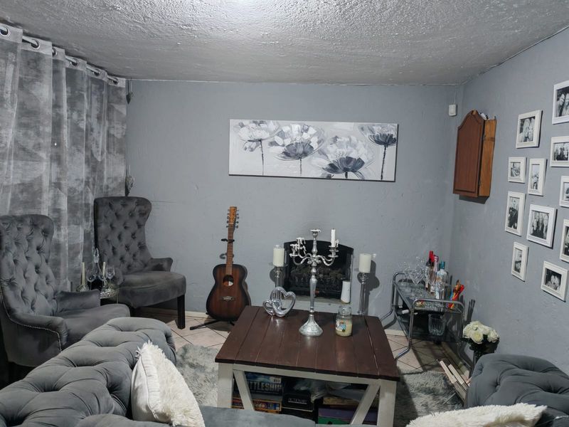 A living room featuring a built-in fireplace and grey painted walls, providing a cozy space for relaxation.