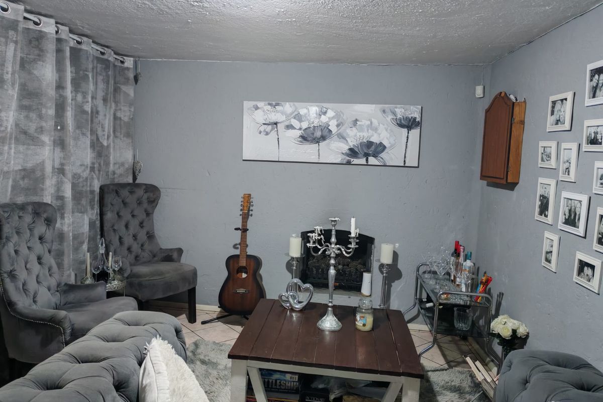 A living room featuring a built-in fireplace and grey painted walls, providing a cozy space for relaxation.