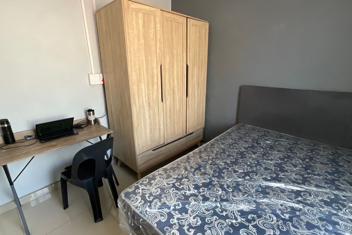A functional bedroom featuring tiled flooring and neutral wall finishes, providing a clean and simple space for rest.