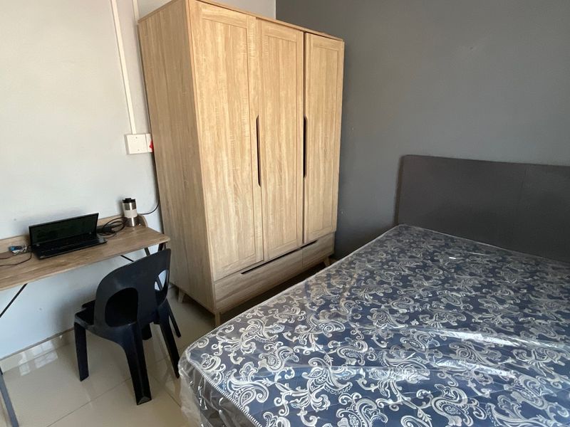 A functional bedroom featuring tiled flooring and neutral wall finishes, providing a clean and simple space for rest.