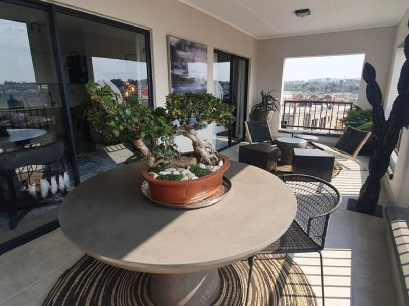 A covered balcony featuring tiled flooring, a metal balustrade, and large sliding glass doors providing access to the interior living space.