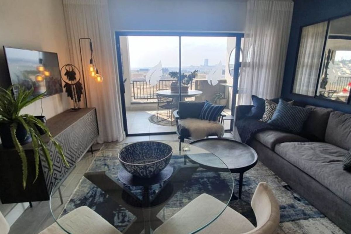 A well-appointed living room featuring large sliding glass doors that open onto a balcony, providing natural light and expansive views.
