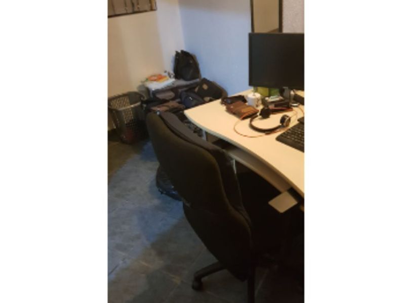A small office space featuring tiled flooring and a window, suitable for a home workspace.