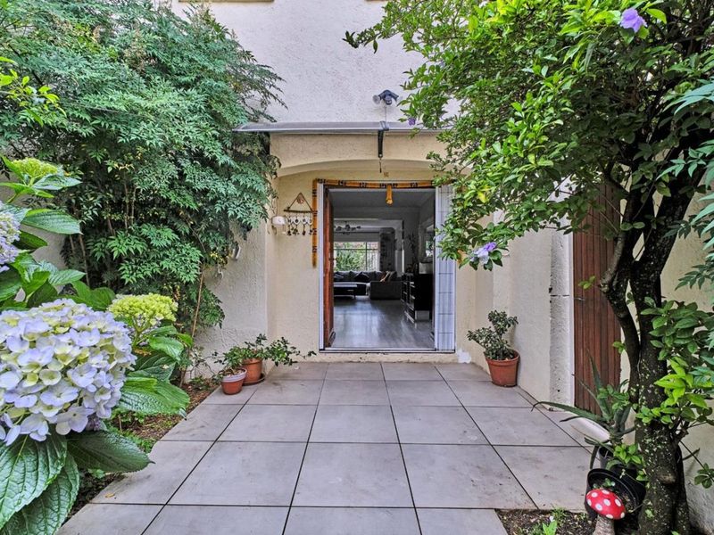A private rear patio area featuring tiled flooring and an overhead awning, providing a seamless transition into the interior living space.