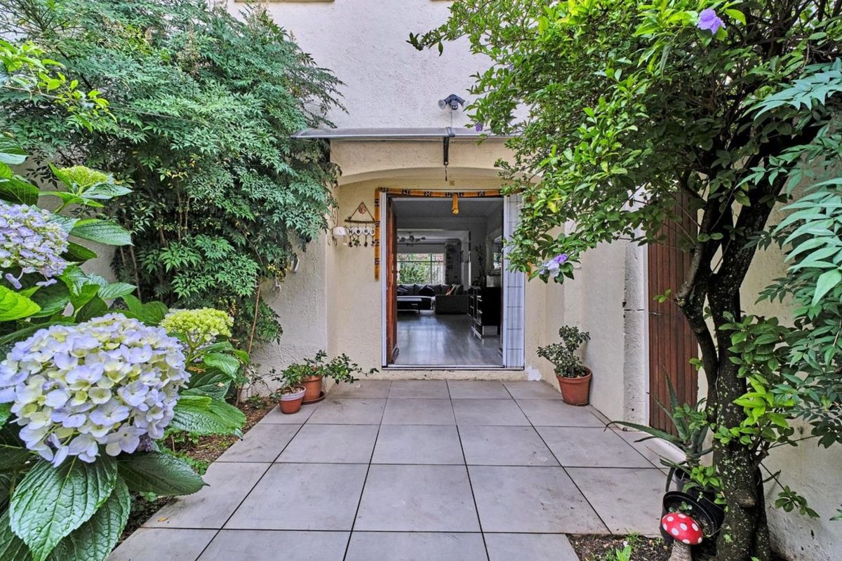 A private rear patio area featuring tiled flooring and an overhead awning, providing a seamless transition into the interior living space.
