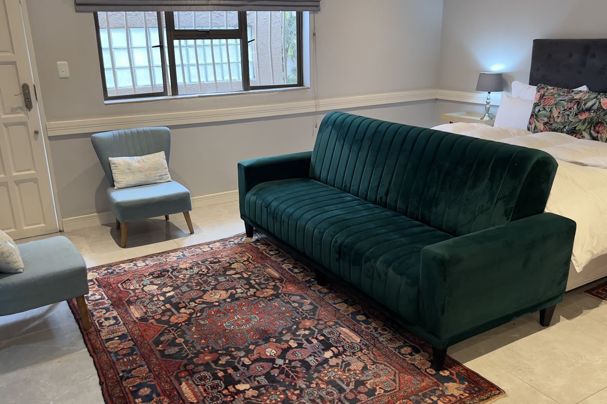 A well-maintained bedroom featuring tiled flooring, chair rail molding, and a window fitted with security bars, providing a functional and comfortable living space.