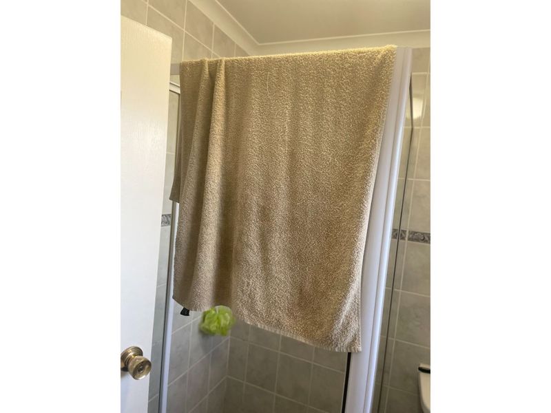 A view of a bathroom shower enclosure featuring tiled walls and coving.